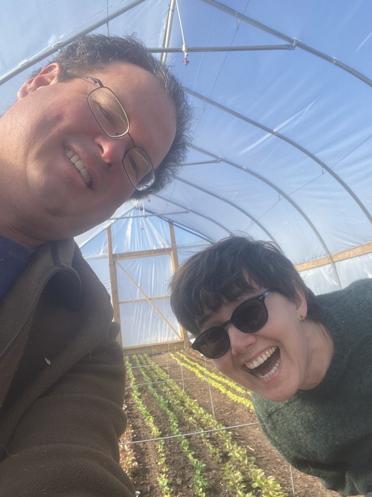 Farmers Chad & Xenia in a high tunnel at Hole in the Woods Farm, a local sustainable farm in Culver, IN